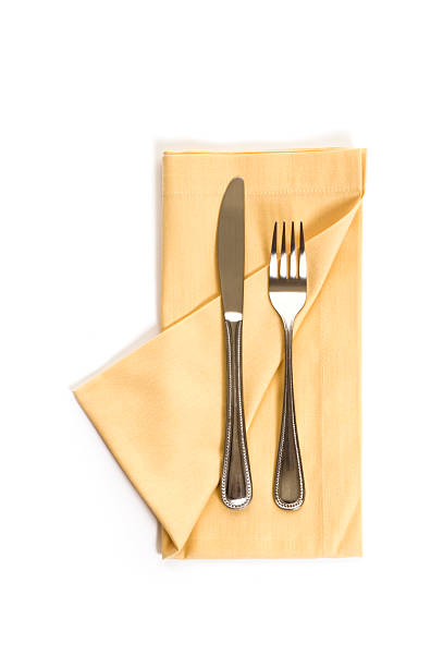 istock Yellow napkin with fork and knife on a white background 471177515
