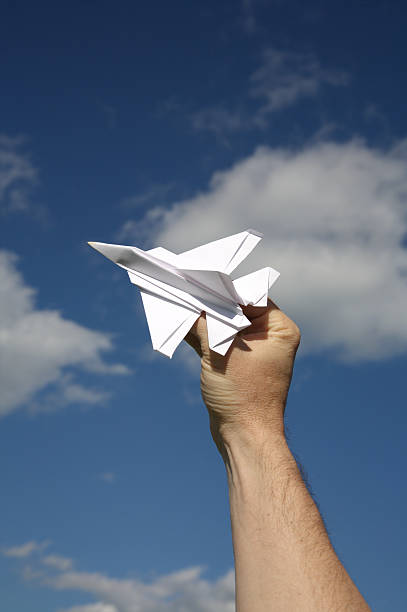 istock Origami Paper Airplane Flying Outside Blue Sky 471178899