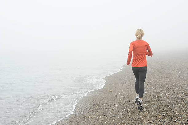 Runner on Foggy Beach stock photo