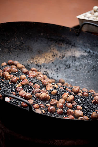 asado castañas de una calle proveedor - chestnut roasted heat roasted chestnut fotografías e imágenes de stock