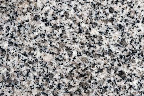 A slab of polished black and white granite intended to be used as a background.  Granite also is popular as a kitchen countertop