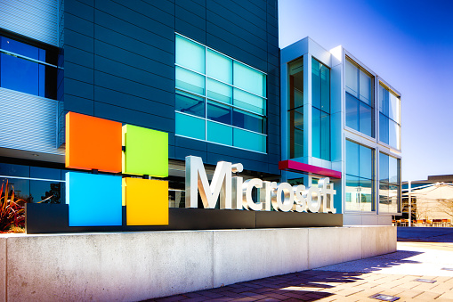 Mountain View, USA - March 4, 2015: Microsoft sign at the entrance of their Silicon Valley campus in Mountain View, California. One of the main buildings can be seen in the background. Oblique view.