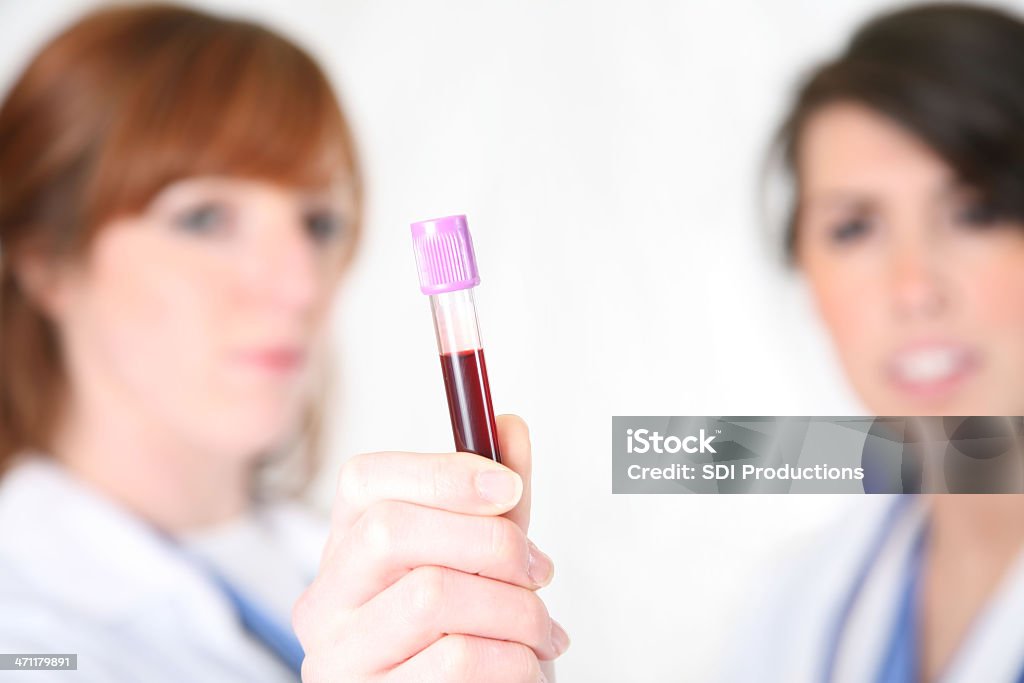 Dois médicos do sexo feminino olhando para tubo de ensaio. - Royalty-free Acidentados Foto de stock