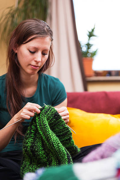 istock pretty knitting woman on a couch 471183046
