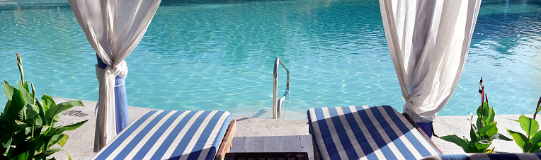 pool with white chairs and natural garden in the background