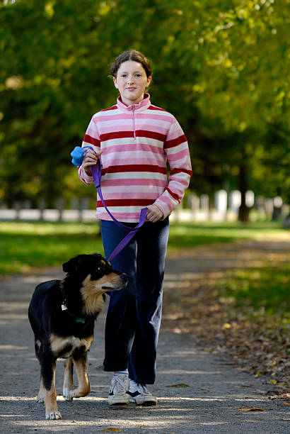 Girl walking her Australian shepherd dog