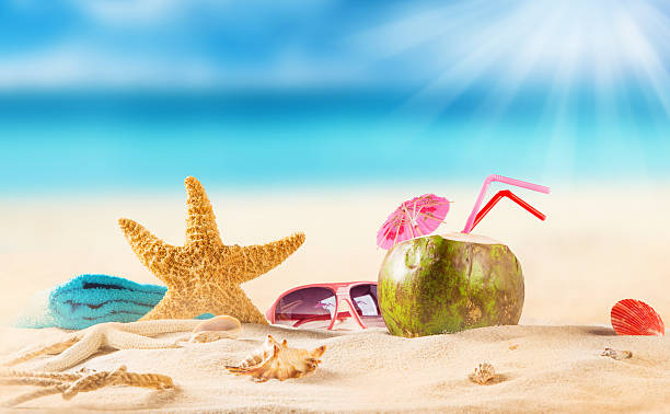 istock Summer-themed display of coconut, shells and towel at beach 471186896