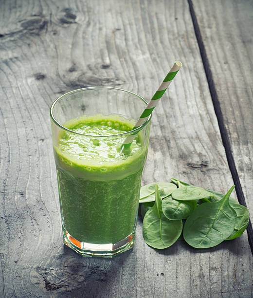 istock Green spinach smoothie in a glass with a straw 471186942