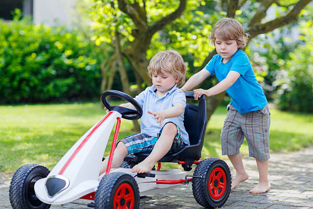 istock Two happy sibling boys having fun with toy car 471187780