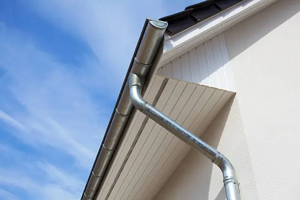 Photo of Architectural close-up of a metal rain gutter with downspout