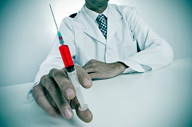 istock sinister doctor with a syringe 471189711