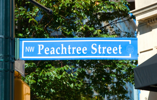 Peachtree Street Sign in Atlanta, with trees and downtown buildings in the background.  Peachtree Street is Atlanta's 