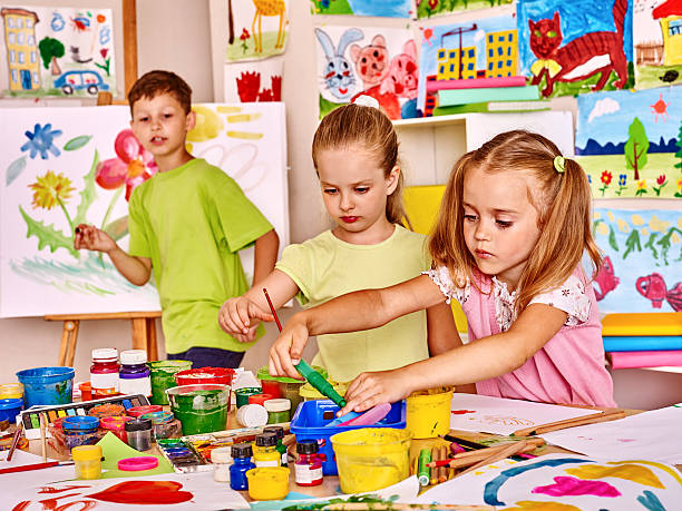istock Child painting at easel 471192012