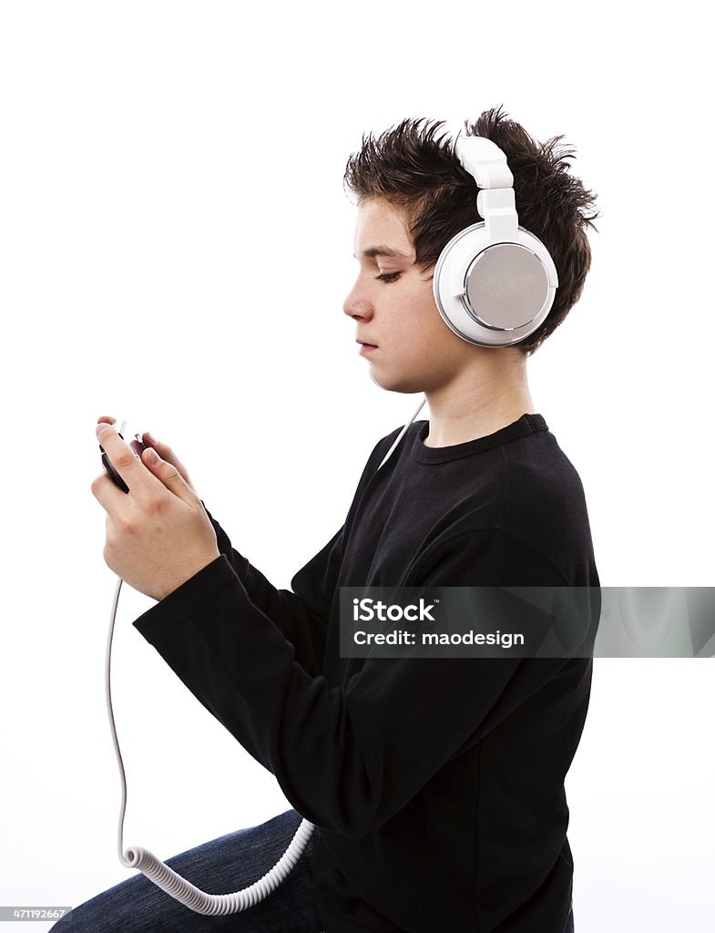 Modern Teenager Teenager with headphones listening to music and playing games at the same time . 14-15 Years Stock Photo