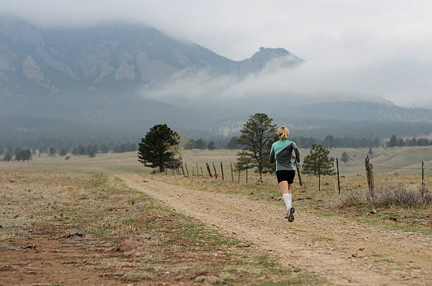 Woman Runner on Mountain Trail stock photo