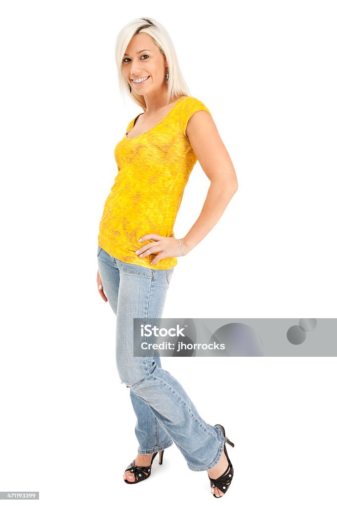 Młoda kobieta o blond włosach bawi się w dżinsy i żółty t-shirtów - Zbiór zdjęć royalty-free (Aparat ortodontyczny)