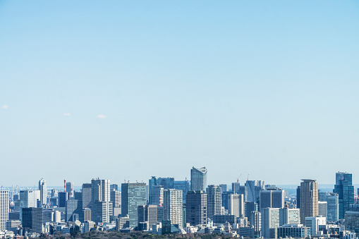 The city skyline of Tokyo, the capital city of Japan. Large skyscrapers dominate the vast cityscape.