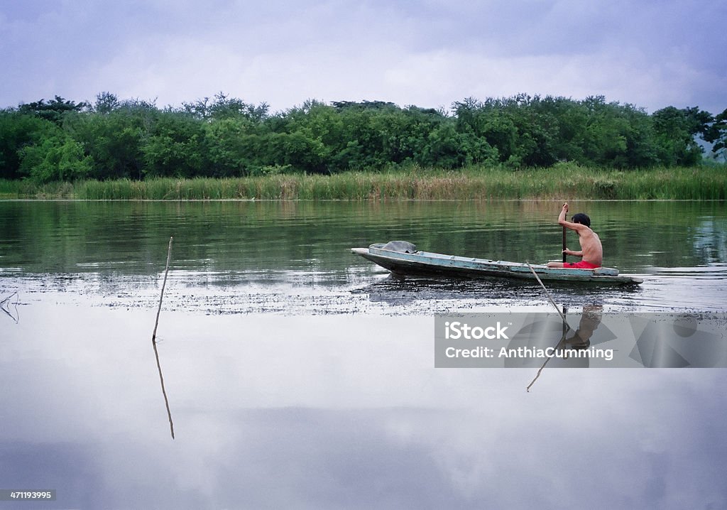 Homem em um barco de madeira, remando em um rio na Tailândia - Foto de stock de Adulto royalty-free