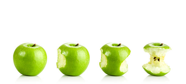 Eating a Green Apple Sequential images of eating a green apple from a full apple to the apple core. apple with bite out stock pictures, royalty-free photos & images