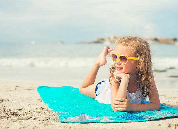 istock Little girl sunbathing on the beach. Place for text. 471194474