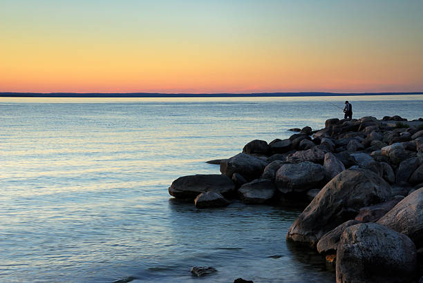 istock Man Fishing on a Rocky Shore 471196219
