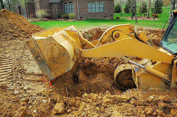 istock Excavator Moving Dirt for New Home Foundation Construction 471196981