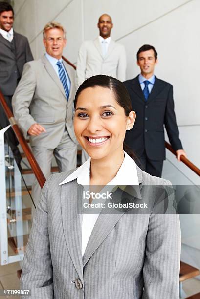 Feliz Mulher De Negócios Com Os Colegas No Fundo - Fotografias de stock e mais imagens de Escadaria - Escadaria, Liderança, Cinco Pessoas