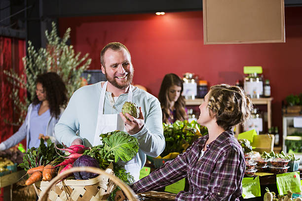 istock Grocery store worker helping customer in produce section 471199986