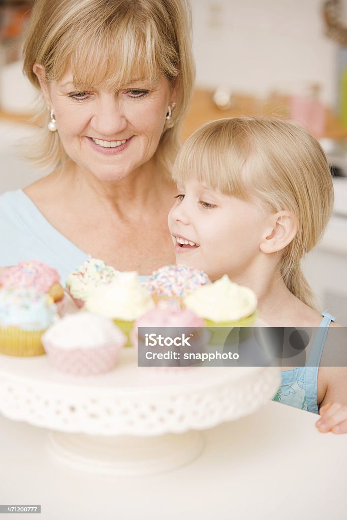 Bambino e donna matura mangiare Cupcake - Foto stock royalty-free di Adulto