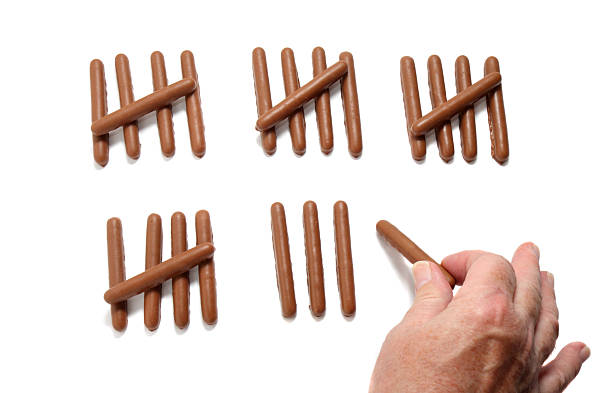 chocolate cookies - fingers counting calories chocolate cookies (chocolate fingers) used to count calories... a hand is adding or subtracting to the count. Concepts - calorie counting / dieting - chocolate "treats" add to calorie intake ... chocolate fingers stock pictures, royalty-free photos & images