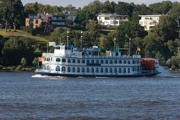a "paddlesteamer" in front of luxurios resential houses in hamburg