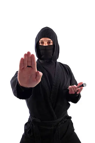 A ninja on a white background extends a halting hand as a command to stop (or a palm-heel strike depending upon interpretation). Perhaps this ninja is saying, "Talk to the hand."