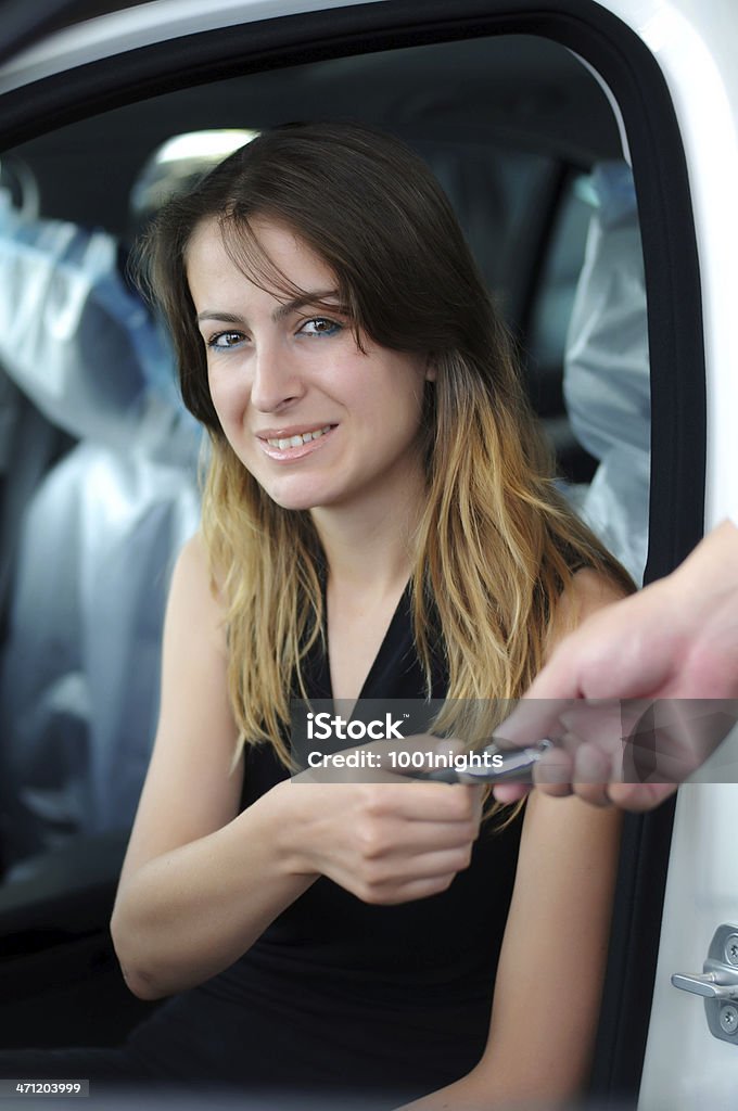 Buying a car Young woman buying a car in auto gallery Adult Stock Photo