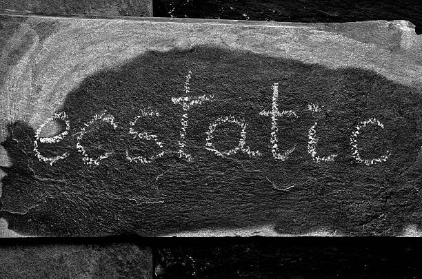 istock The word ECSTATIC written with chalk on black stone 471205580