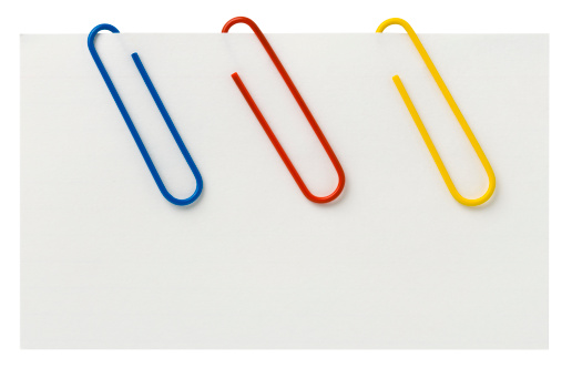 Three colorful Jumbo Paperclips attached to a blank white Index Card. Clipping Path. Clone out the paperclips you don't want. Index card is over 8\