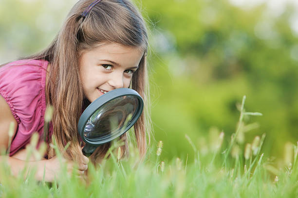 istock A young girl playing with a magnifying glass 471206093