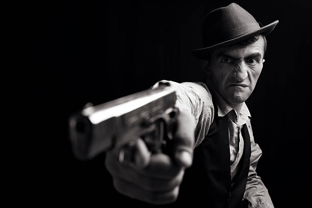 Man, suit or shooting gun on dark studio background in secret spy, isolated mafia leadership or crime lord security. Model, gangster or hitman firing gun in style, formal or fashion clothes aesthetic