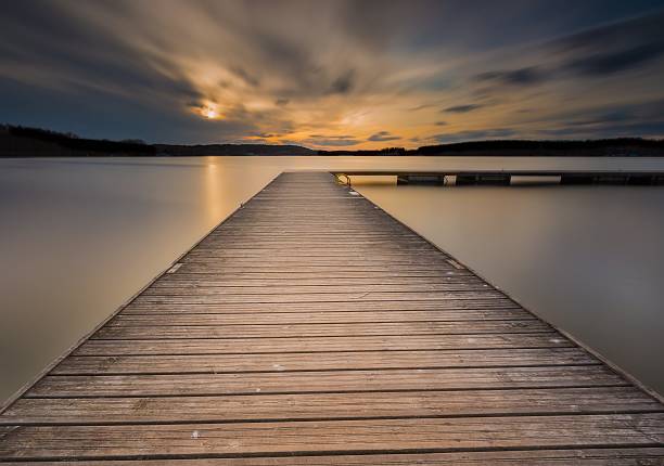 istock Beautiful long exposure lake with jetty at sunset. 471207094