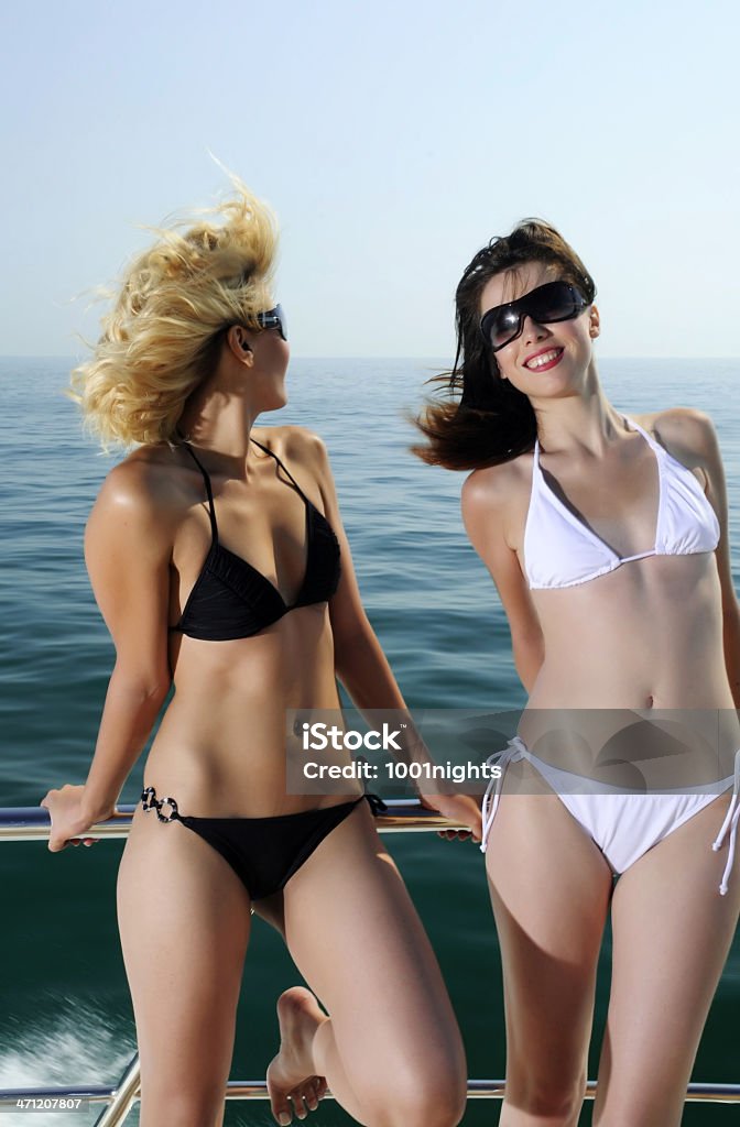 Duas jovens mulheres em biquíni debruçado sobre o parapeito de barco - Foto de stock de 20 Anos royalty-free