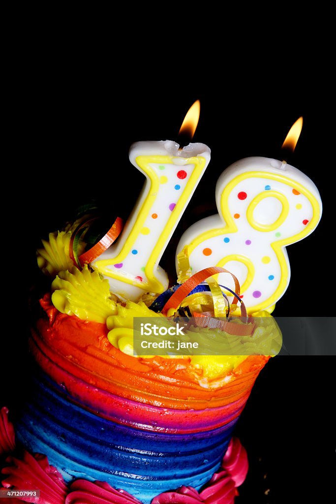 18th Birthday Cake A colorful birthday cake on a black background with an "18" candle Birthday Stock Photo