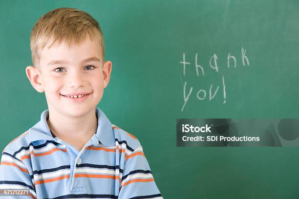 Aluno Da Escola Primária Posando Depois De Escrever Obrigado Na Escola Chalkboard - Fotografias de stock e mais imagens de Acontecimentos da Vida