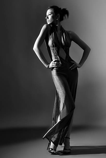 istock Fashion model in long clothes on dark background 471212287