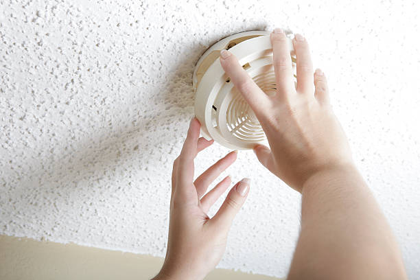 Smoke Detector Female hands opening smoke detector to change battery. smoke detector photos stock pictures, royalty-free photos & images