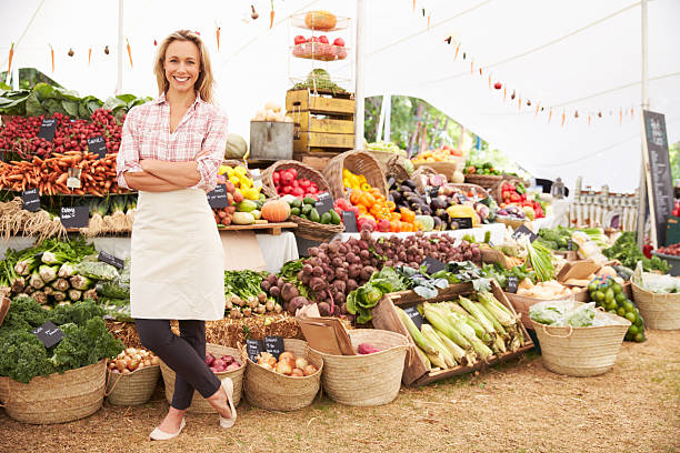 Large fresh food market with employee Female Stall Holder At Farmers Fresh Food Market, Strading And Smiling To Camera market stall stock pictures, royalty-free photos & images