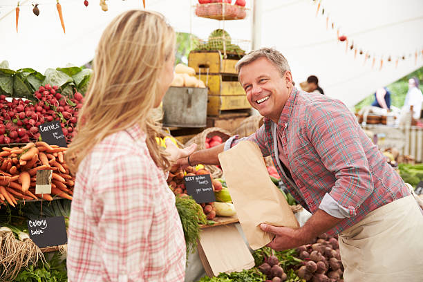 istock Smiling man selling vegetables to a woman 471212778
