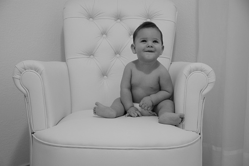 my son smiling and playing on the armchair