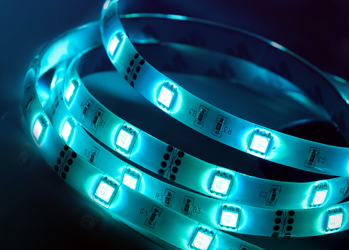 Led strip coil closeup. Diode shining rope on dark blue background.
