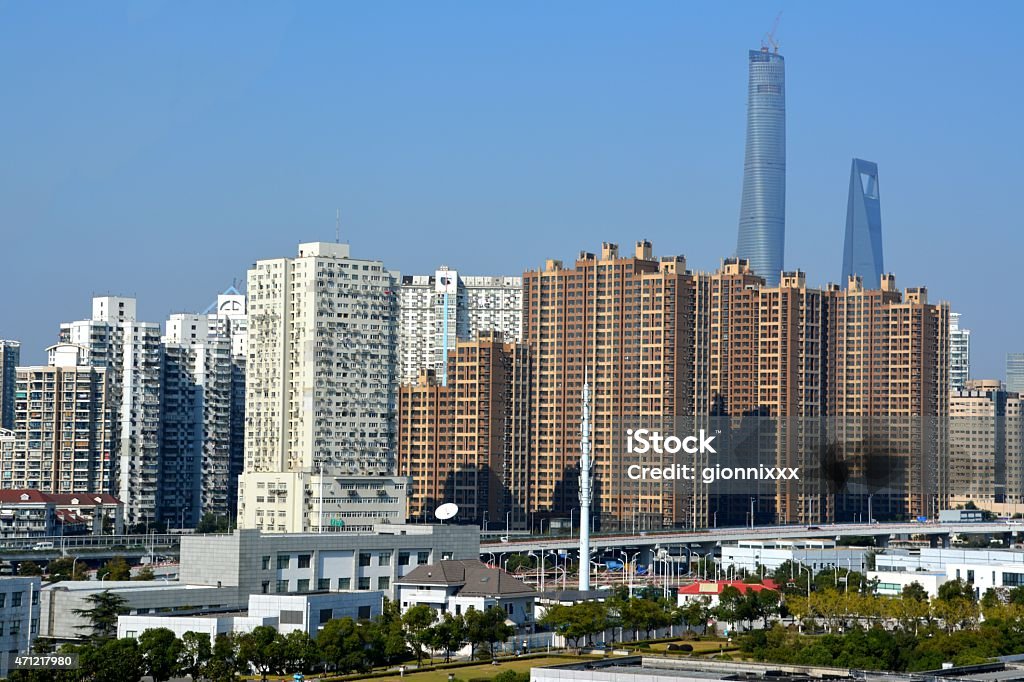 Shanghai urban development cityscape Shanghai urban development cityscape. A new residential area with tall, modern apartment buildings, surrounded by the two supertall skyscrapers, Shanghai Tower and Shanghai World Financial Center.   2015 Stock Photo