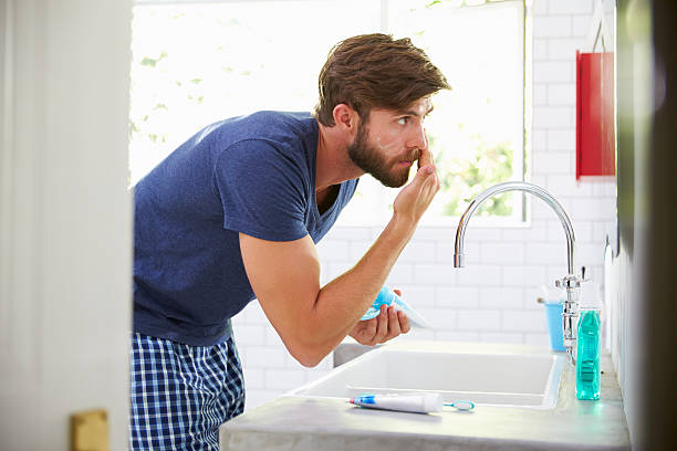 istock Man In Pajamas Putting On Moisturizer In Bathroom 471219086