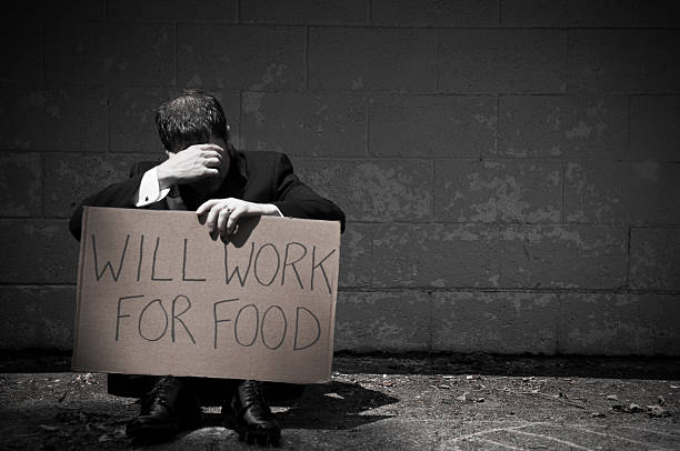 istock Unemployed Businessman Holding Will Work For Food Sign 471220007